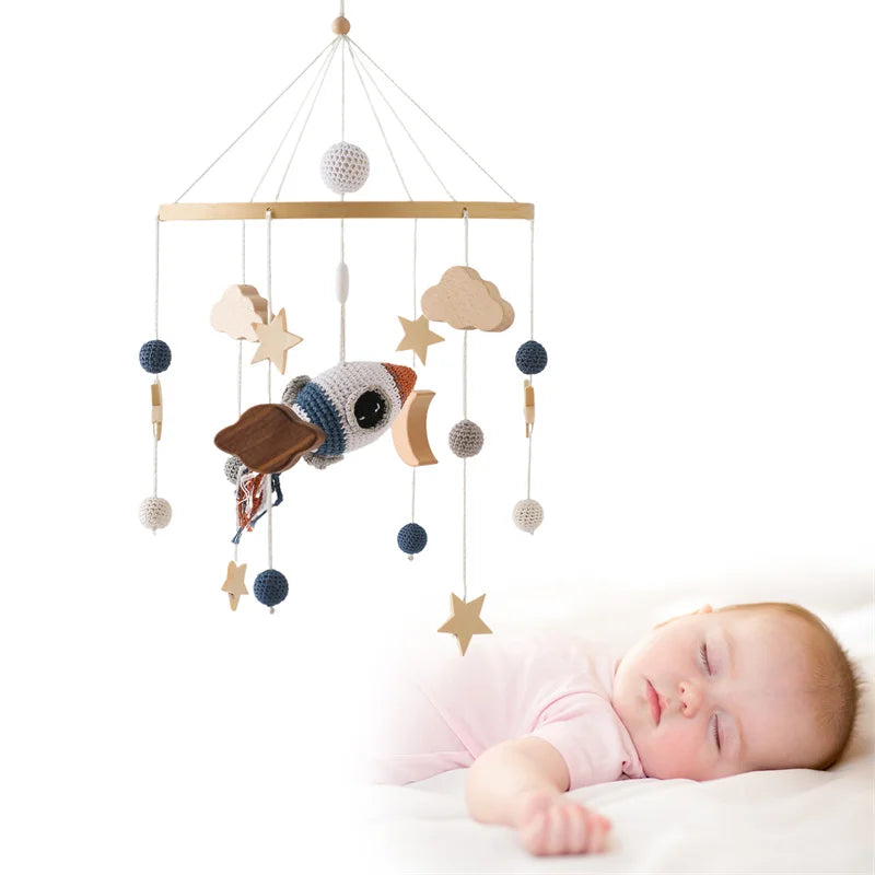 Handmade crochet baby mobile with rocket, stars, and clouds for crib.