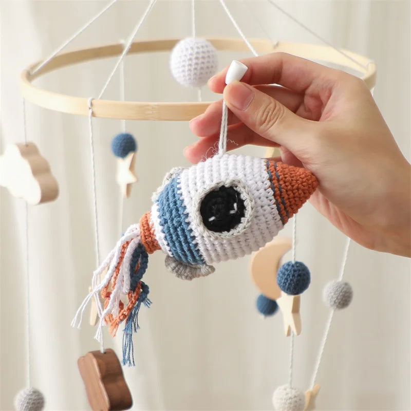 Natural wood and soft cotton rocket baby mobile in space theme.