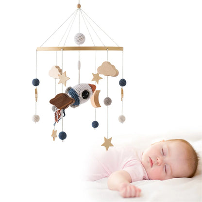 Handmade crochet baby mobile with rocket, stars, and clouds for crib.