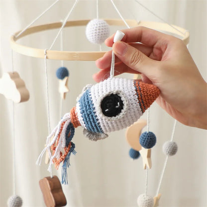 Natural wood and soft cotton rocket baby mobile in space theme.